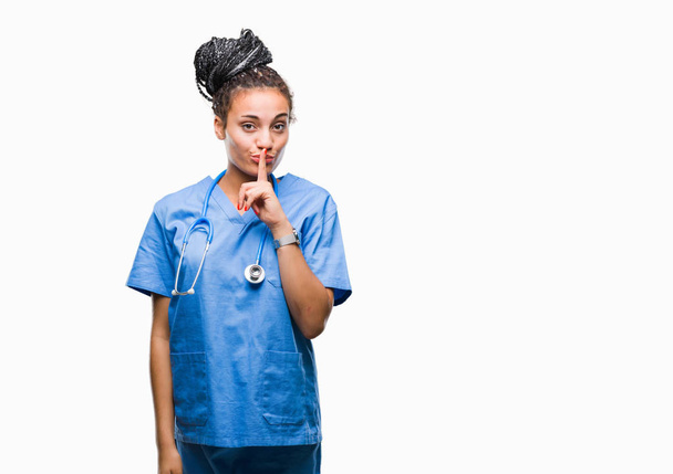 Young braided hair african american girl professional surgeon over isolated background asking to be quiet with finger on lips. Silence and secret concept. - Photo, Image