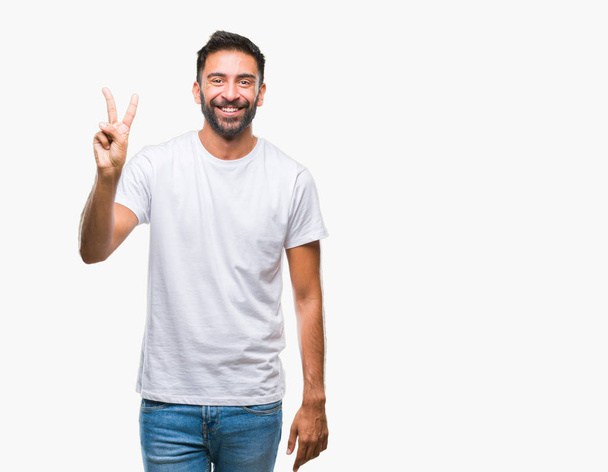 Uomo ispanico adulto su sfondo isolato mostrando e indicando con le dita numero due sorridendo fiducioso e felice
. - Foto, immagini