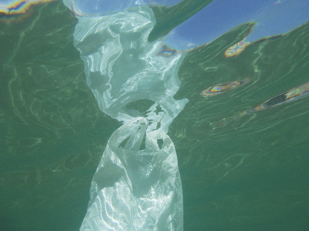 Bolsa de plástico flotando en el mar. Medio ambiente contaminado. Reciclar basura
                             - Foto, imagen