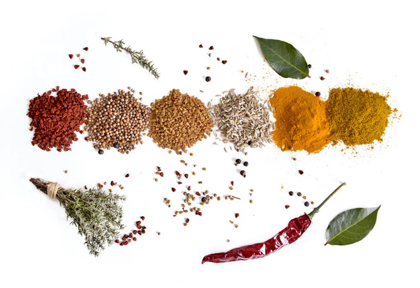 top view on heaps of indian powder spices with thyme and pepper on white background - Photo, Image
