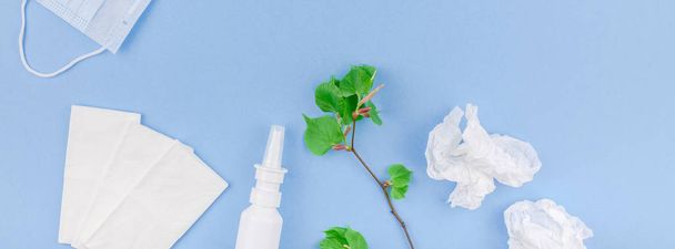 Creative flat lay concept of seasonal spring pollen allergy with napkins, pills, face mask, drops in a bottle and fresh green sprouts. Copy space long wide banner minimal style, template for text - Photo, Image