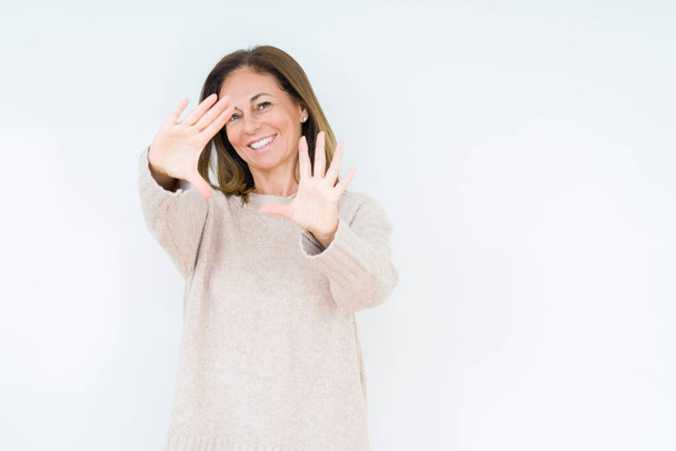 Красивая женщина среднего возраста на изолированном фоне улыбается делая рамку с помощью ладоней и пальцев, камеры перспективы
 - Фото, изображение