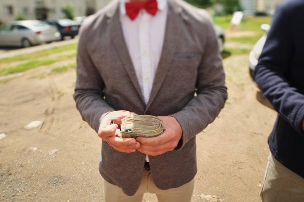man in a red bow tie holding a wad of money - Фото, зображення