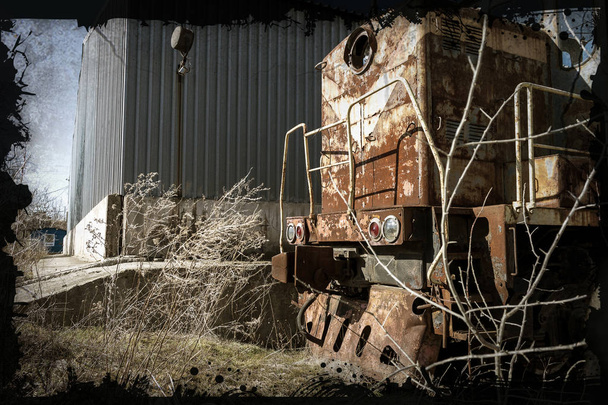 Old rusty train locomotive thrown into exclusion zone of Chernobyl. Zone of high radioactivity. Ghost town of Pripyat. Chernobyl disaster. Rusty abandoned Soviet machinery in area of nuclear accident at plant - Photo, Image