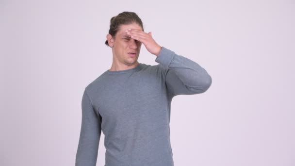 Hombre estresado cubriendo los ojos contra fondo blanco
 - Metraje, vídeo