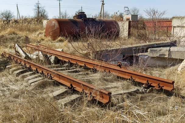 Old abandoned railway, broken rails, broken wooden sleepers. Broken remains of railway. Plundered old railway. There is no road. Debris, remnants, elements of old canvas. Selective focus - Photo, Image