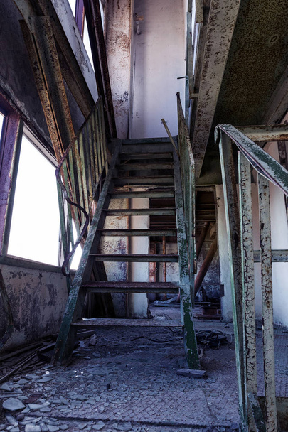 alte zerstörte Betontreppe im Inneren der Ruinen des unvollendeten Verwaltungsgebäudes des Geschäftszentrums. Ruinierte alte Treppe im Inneren eines verlassenen Fabrikgebäudes - Foto, Bild