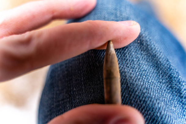 Kugel nach einem Schuss auf den Blue-Jeans-Hintergrund mit ballistischen Spuren darauf - Foto, Bild