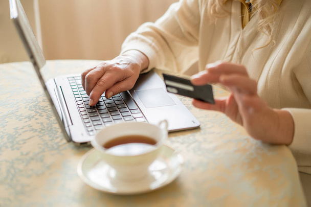 Close-up view of credit card, laptop and a cup of tea - 写真・画像