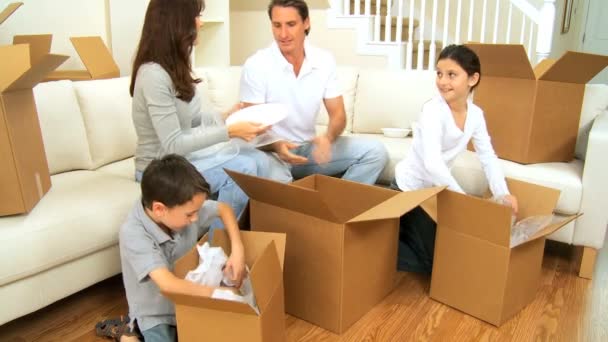 Nuori valkoihoinen perhe purkaa tavaroita uudessa kodissa
 - Materiaali, video