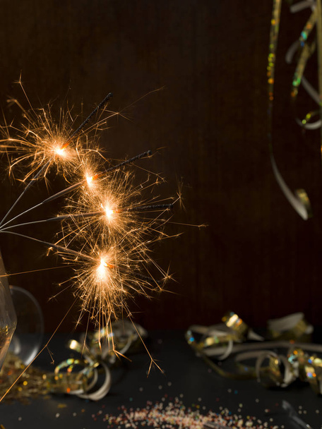 new year background with burning sparklers and Christmas items on background   - Foto, Bild