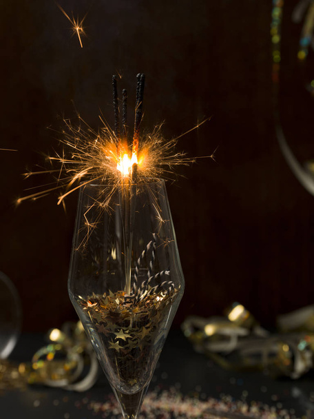 new year background with burning sparklers in glass and Christmas items on background   - Fotó, kép