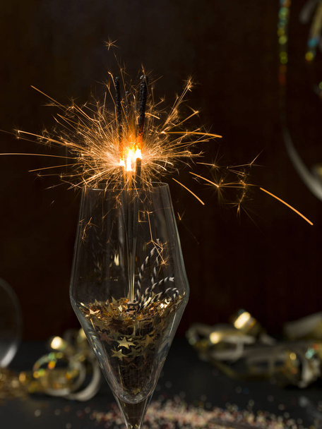 new year background with burning sparklers in glass and Christmas items on background   - Zdjęcie, obraz