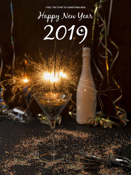 new year background with burning sparklers in glass and champagne bottle with Christmas items on background   - Foto, immagini