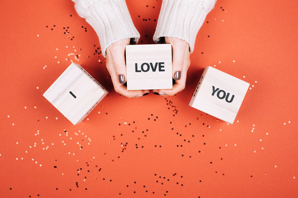 Wonans hands holding cubes with text I Love You. Flat lay style. Living Coral - Color of the Year 2019. - Foto, afbeelding