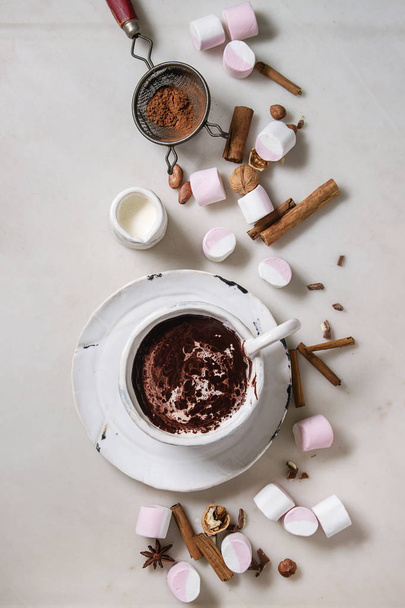 Ceramic cup of hot chocolate with marshmallow s'mores with ingredients above over white marble table. Winter drink. Flat lay, space - Fotoğraf, Görsel