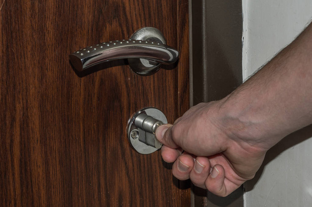 The hand opens the door with a key - Foto, imagen