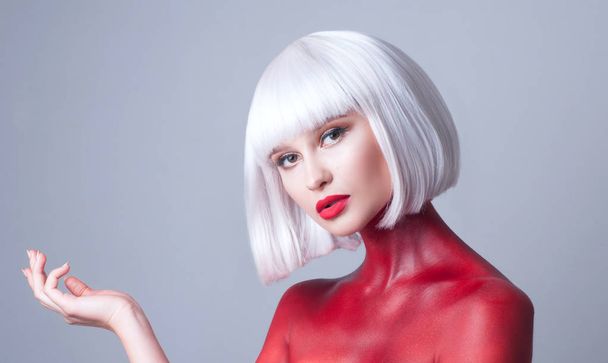 Портрет молодої красивої жінки з білим волоссям червоні губи і червоне тіло-мистецтво на білому тлі
 - Фото, зображення