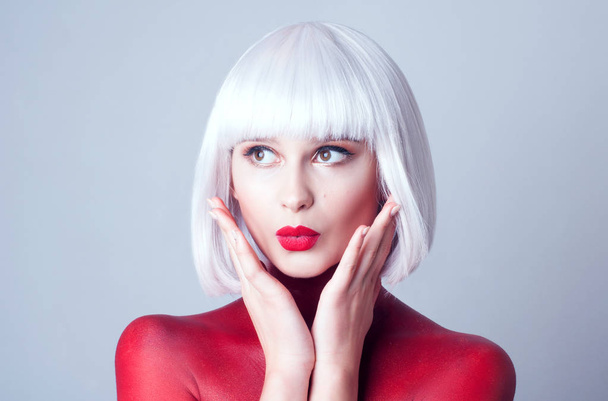 Портрет молодой красивой женщины с белыми волосами, красные губы и красное тело-арт на белом фоне
 - Фото, изображение