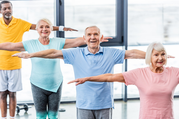 Hochwinkel-Ansicht von multikulturellen Senioren-Athleten synchron beim Turnen im Fitnessstudio - Foto, Bild