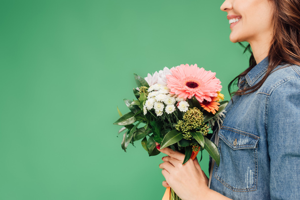 cropped view of woman holding flower bouquet isolated on green - Foto, imagen