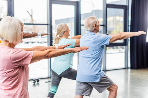 Rückansicht Senioren-Synchronsportler beim Turnen im Fitnessstudio - Foto, Bild