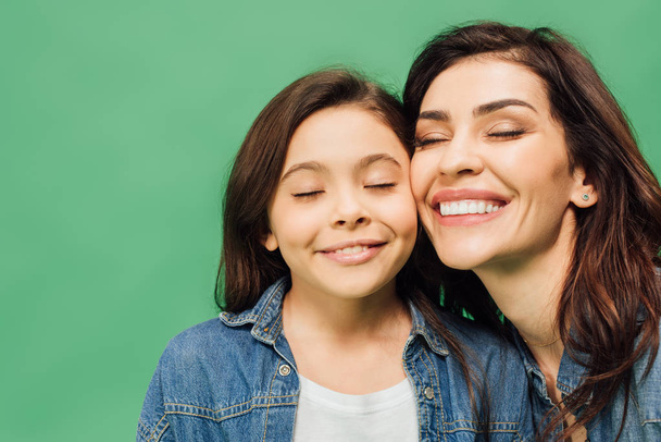 portrait of beautiful mother and daughter with eyes closed isolated on green - Photo, Image
