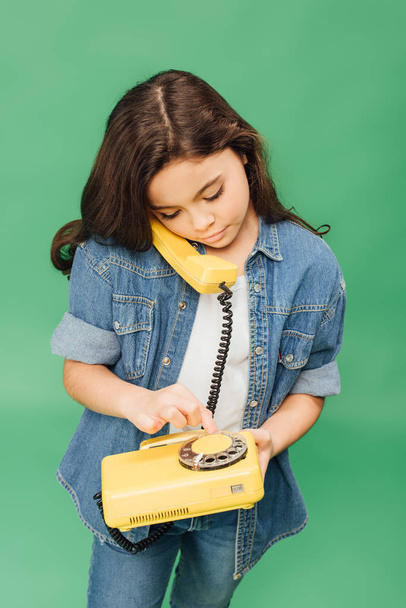 aranyos gyermek elszigetelt zöld sárga vintage telefonon beszél - Fotó, kép