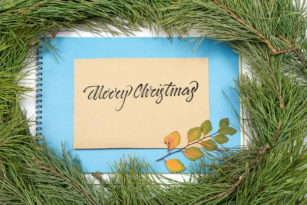 Christmas Greeting Card. Fir Branch And Decoration On Plank With Lettering Merry Christmas. Christmas Fir Tree On Wooden Background with Letter. Copy Space - Фото, зображення