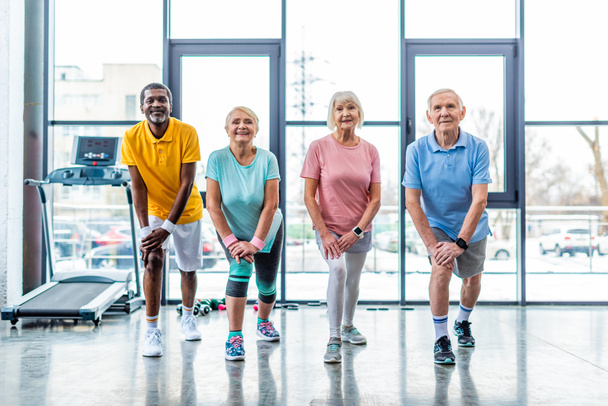 joyeux seniors sportifs multiethniques synchrones étirement à la salle de gym
 - Photo, image