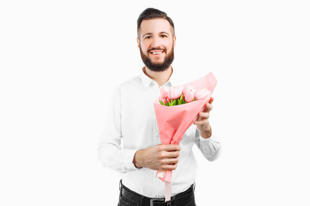 Elegant man with a beard holding a bouquet of tulips, a gift for Valentine's Day. On a white background - Photo, Image
