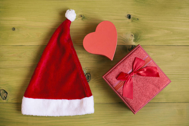 Изображение Санта-Шляпы и подарки на деревянном столе.
. - Фото, изображение