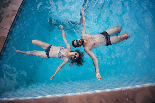 Una joven pareja de amantes nada en la piscina
.  - Foto, Imagen