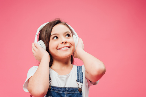vidám gyermek zene és megható fejhallgató elszigetelt rózsaszín  - Fotó, kép