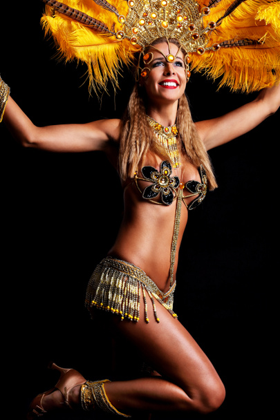 Brazilian woman posing in samba costume over black background - Fotó, kép