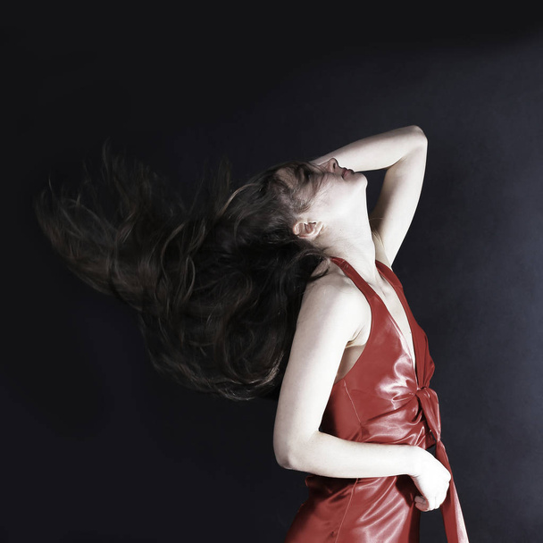 portrait of glamorous young woman in a red dress. - 写真・画像