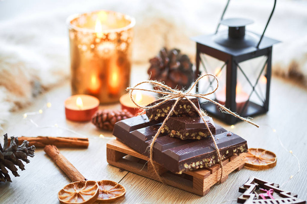 Typical Spanish Christmas chocolate turron or nougat on wooden table with decorations and candles. New Year and holidays season. Cozy atmosphere. - Fotografie, Obrázek