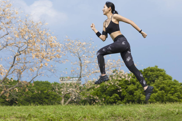 Young Asian woman smiling jogging in the park - Foto, immagini