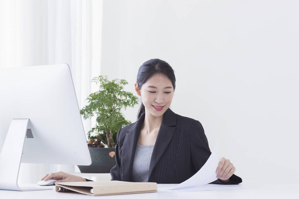 Joven mujer asiática sentada en el escritorio y usando su computadora
 - Foto, imagen