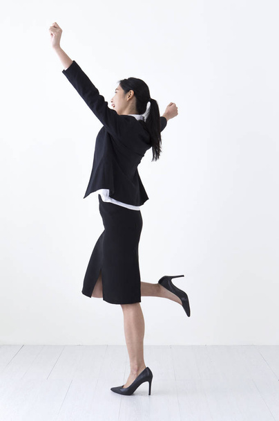 Young Asian woman wearing a suit hands up and looking away - Fotoğraf, Görsel