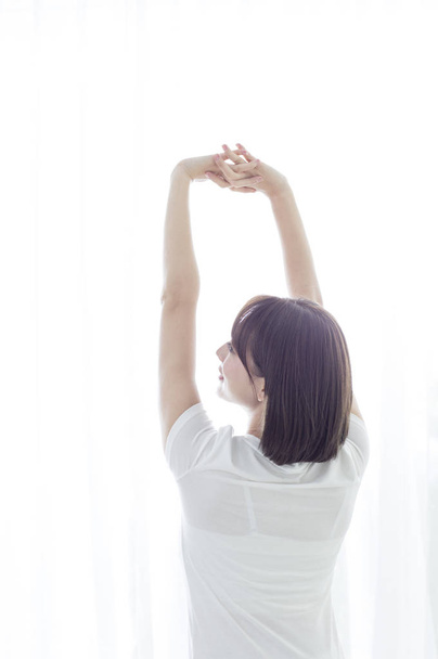 Young Asian woman hands up and stretching her body - Foto, imagen