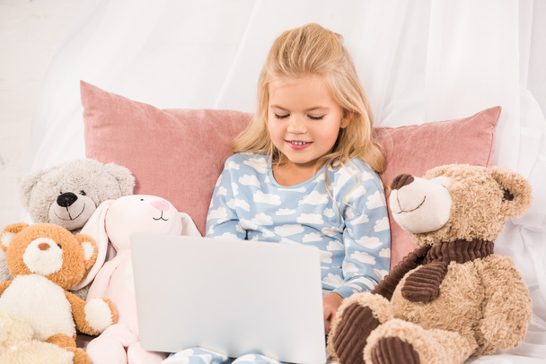 adorável criança assistindo desenhos animados na cama
 - Foto, Imagem
