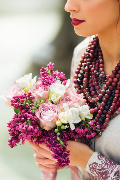 neck with beads. a beautiful wedding bouquet with lilacs and roses - Valokuva, kuva