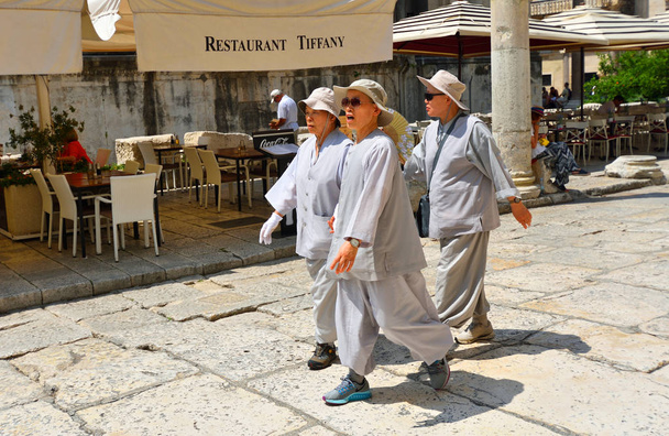 Split, Kroatien - 21. Juni 2018: chinesische Touristinnen in Sonnenschutzanzügen in der gespaltenen Altstadt. - Foto, Bild