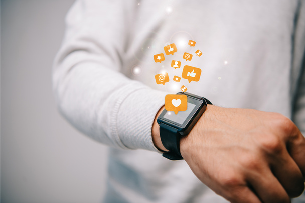 cropped view of man with smartwatch with multimedia icons - Photo, Image