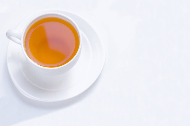 Апельсиновый травяной ароматизированный рождественский чай с корицей и кардамоном медовый белый стаканчик на белом деревянном столе
  - Фото, изображение
