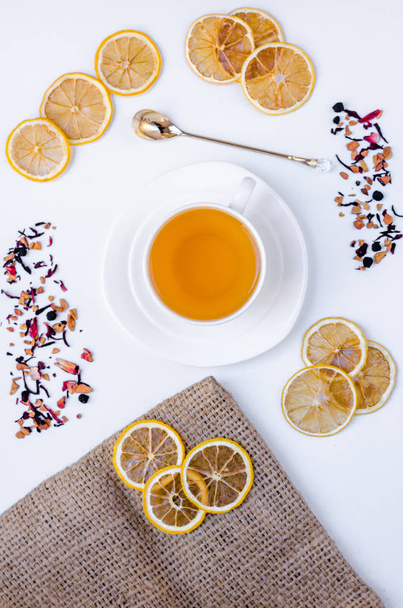 Oranje kruiden smaak kerst thee met kaneel en kardemom honing witte kop op een witte houten tafel  - Foto, afbeelding