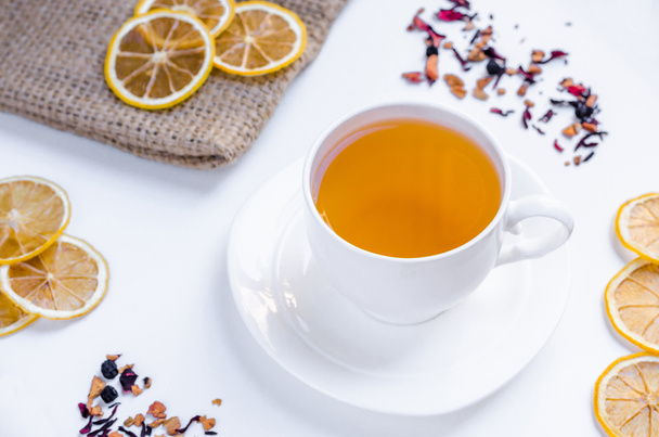 Orange herbal flavored christmas tea with cinnamon and cardamom honey white cup on a white wooden table  - Photo, Image