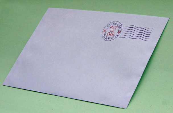 Envelope with postal stamp illustrating the concept of blackmail for extortion - Photo, Image