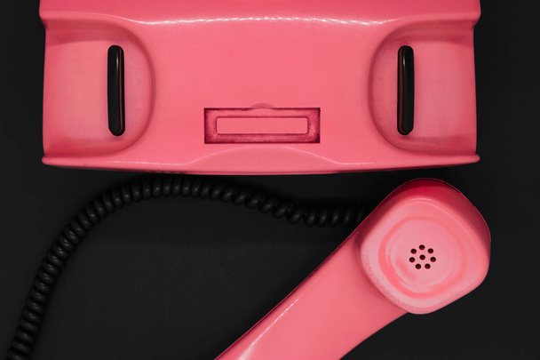 Top view of old and dirty pink retro telephone on black background surface - Photo, Image
